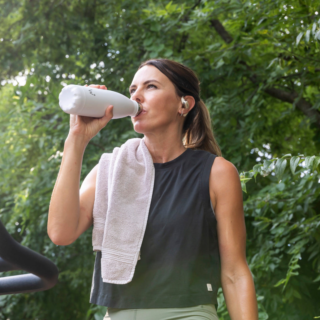 Woman working out and drinking from Water.io smart bottle