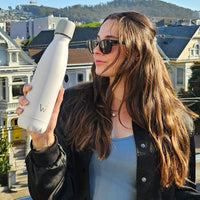 Woman holding Water.io bottle outside