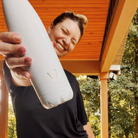 Woman holding Water.io bottle outside