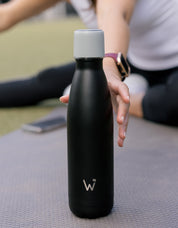 Woman reaching for black 17oz Water.io bottle