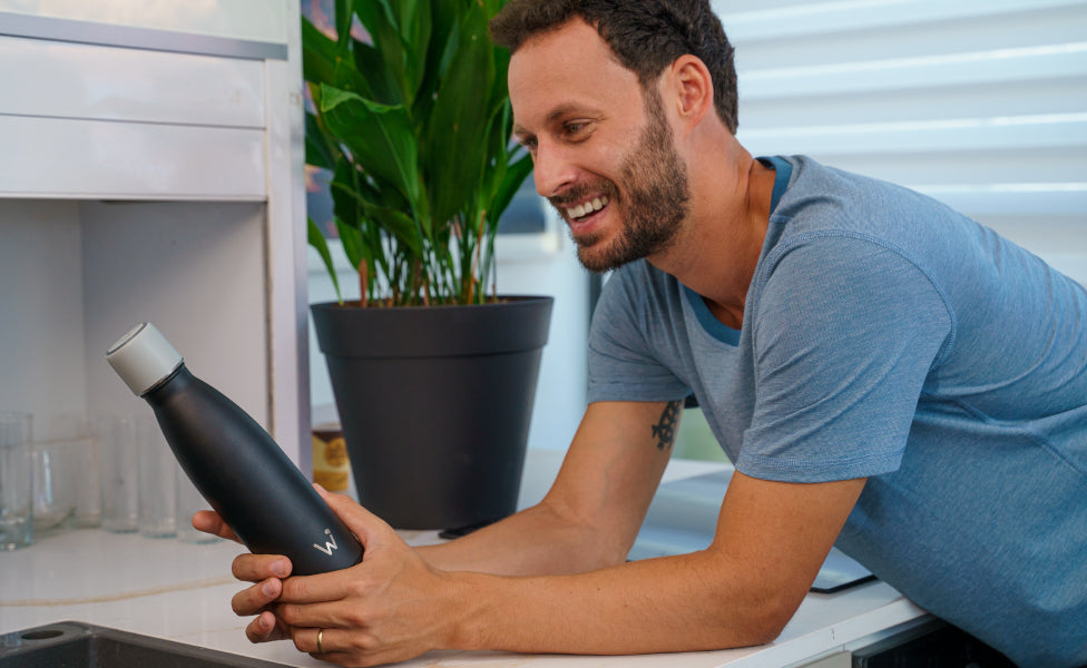 Man smiling and holding Water.io bottle