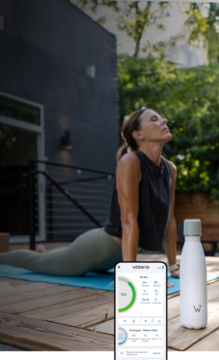 Woman doing yoga outside with Water.io bottle and smartphone sitting on ground 