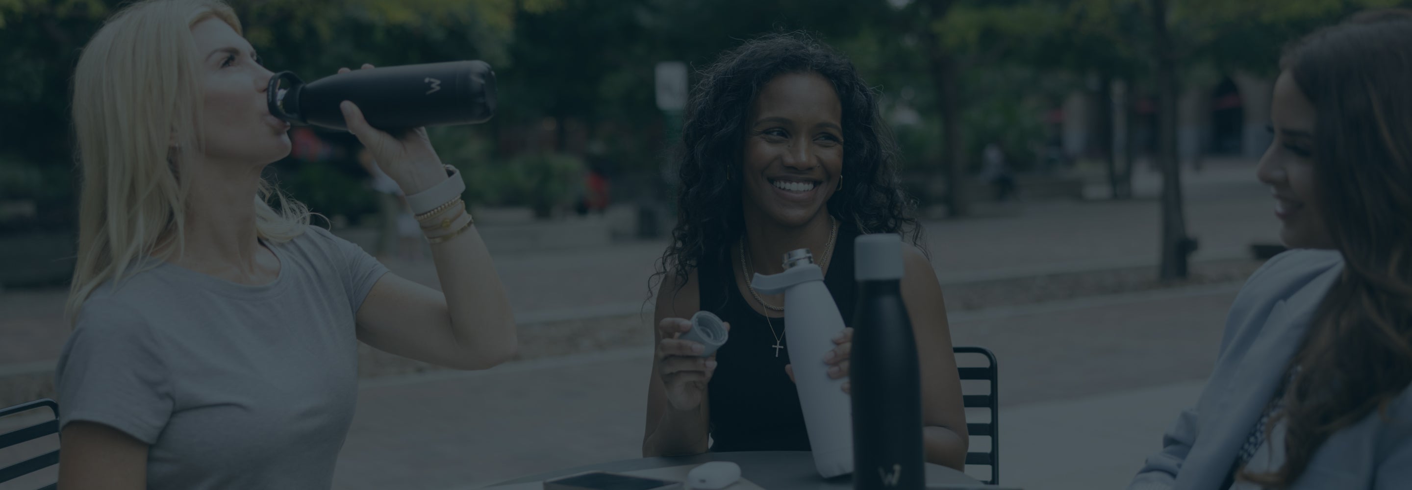 Women chatting and drinking from Water.io bottles