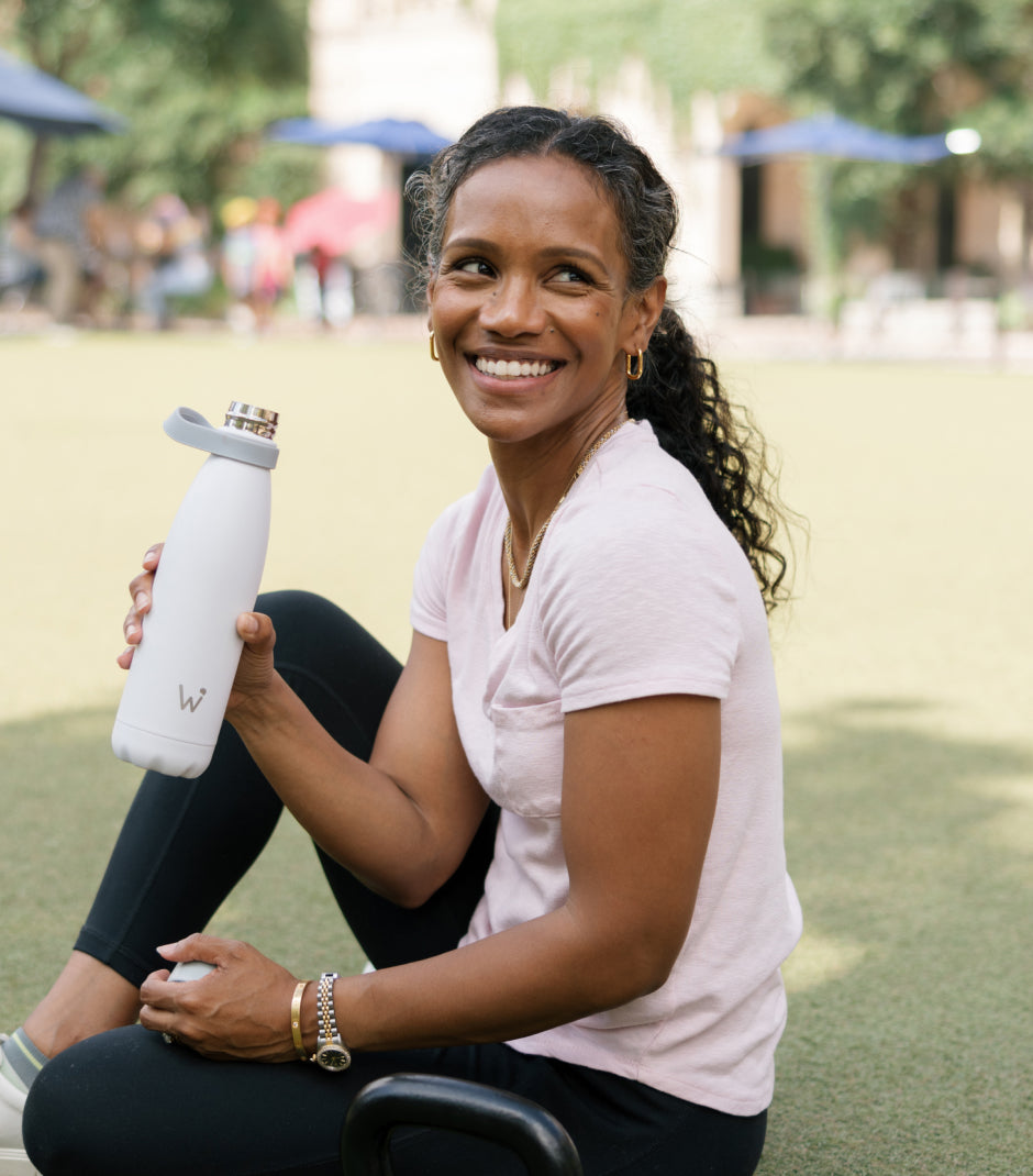 Woman smiling and holding Water.io bottle