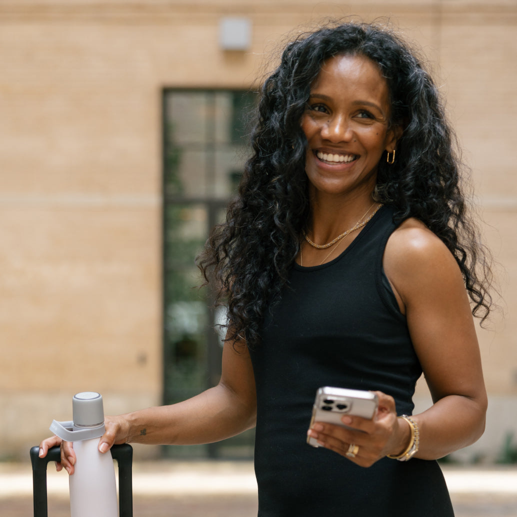 Woman smiling and holding her Water.io bottle